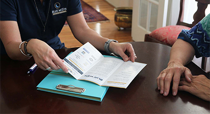 Image of man holding paperwork that features the Blue Moon Estate Sales logo